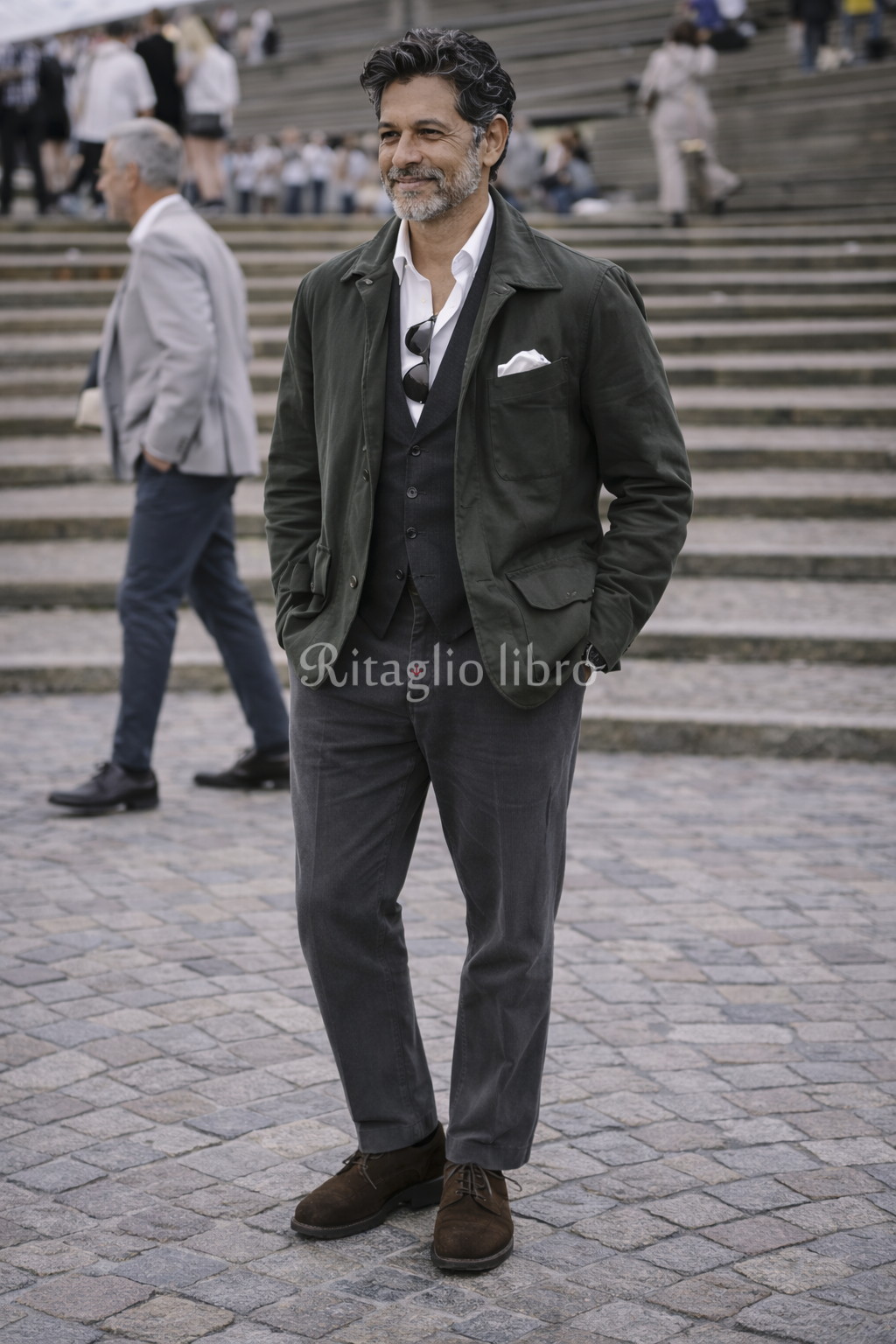 50代男性が、イタリアの街中で撮影した、ミリタリー調ブルゾンとグレースラックスのコーディネートスナップ